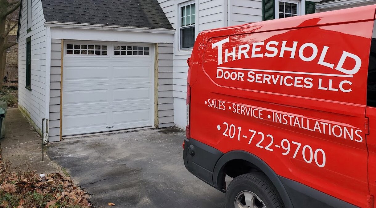Threshold Door Services, LLC truck in from on garage door on clapboard house